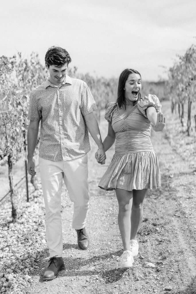 kinsley and jack walking through vineyard in black and white