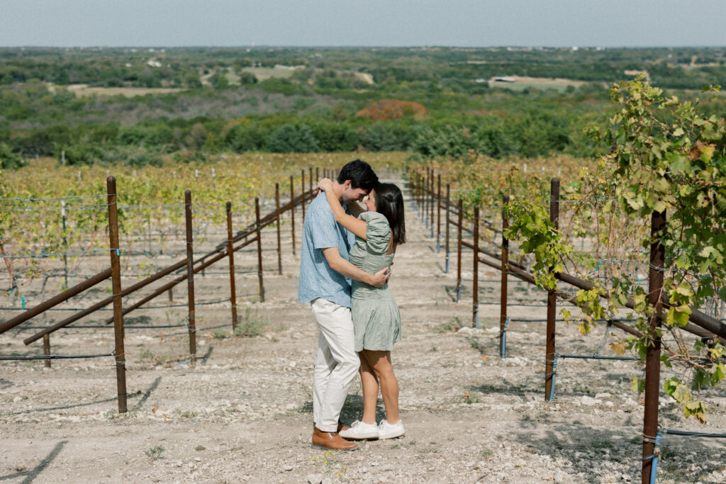 the couple standing in the vineyard