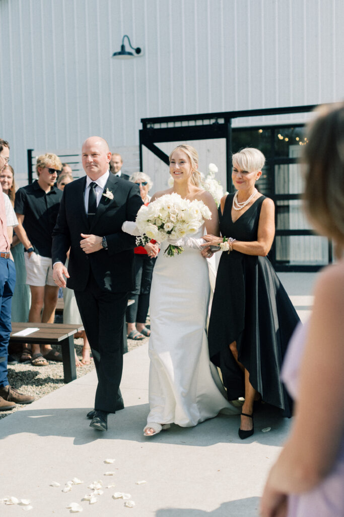 bride walking down the aisle with her parents