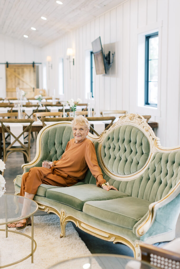 grandma smiling on fancy couch inside the pines venue 