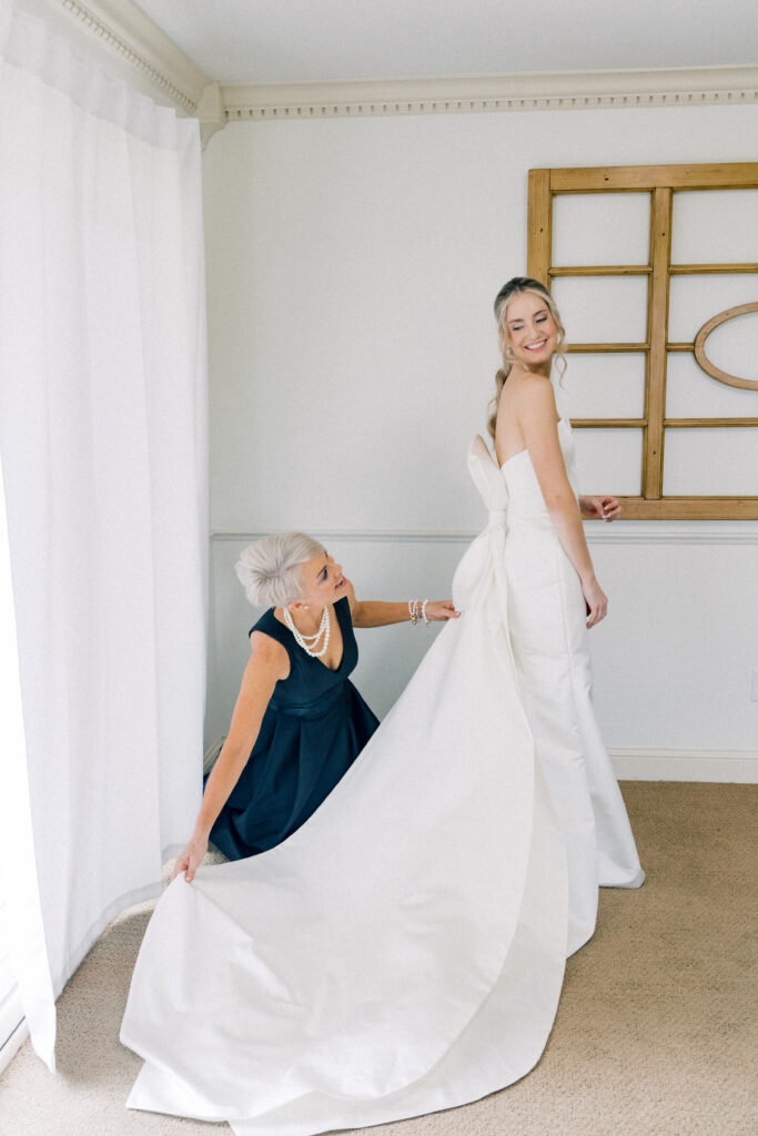 Mother of Bride fluffing brides dress