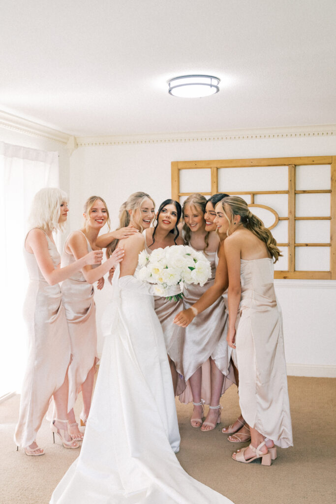 bride and bridesmaids hugging 