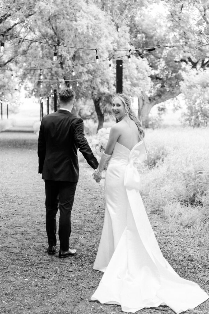 black and white photo of bride and groom walking