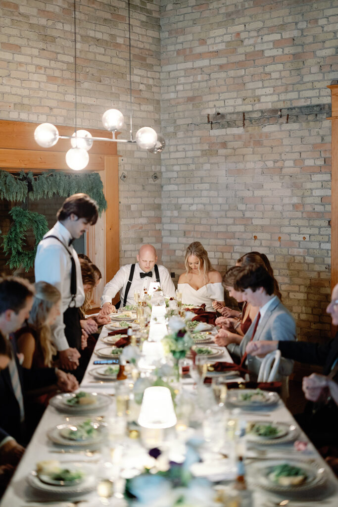 bride and groom praying at reception
