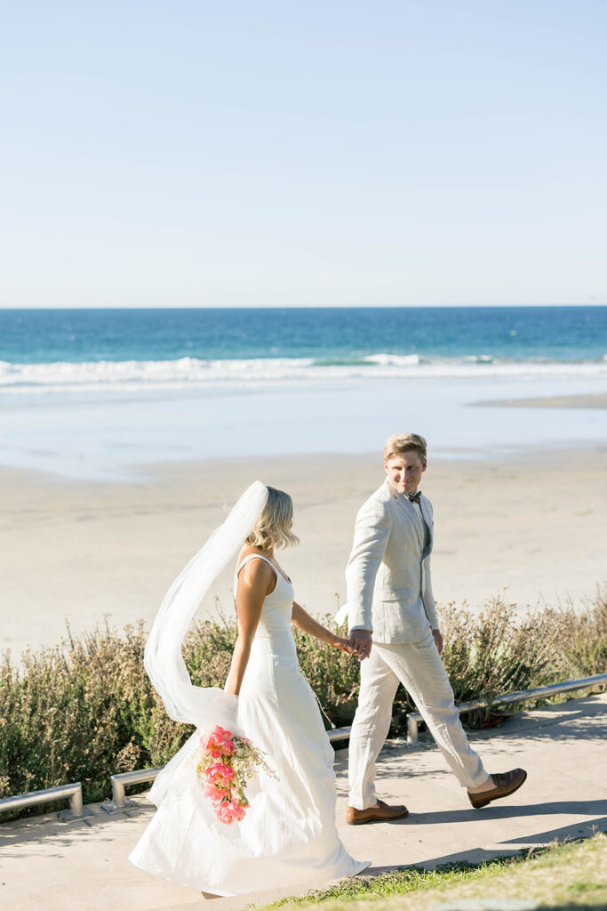 Couple walking along the shoreline during a Scripps Seaside elopement