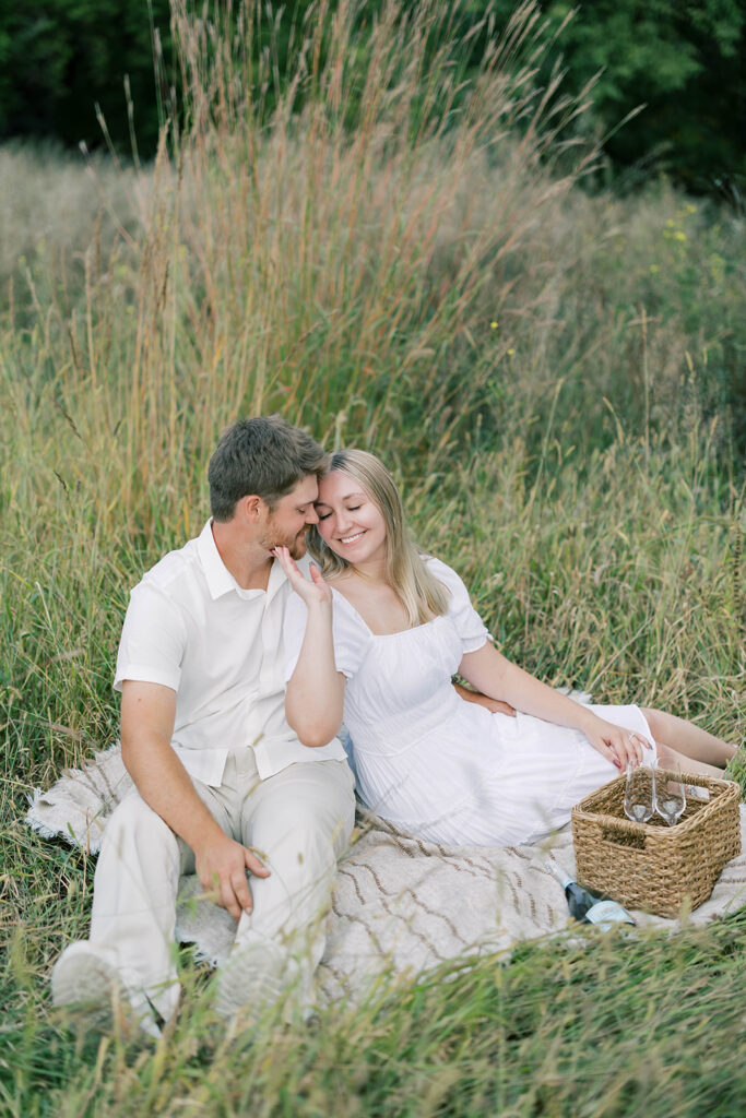 engagement session location idea, couple posing on a picnic blanket in a park