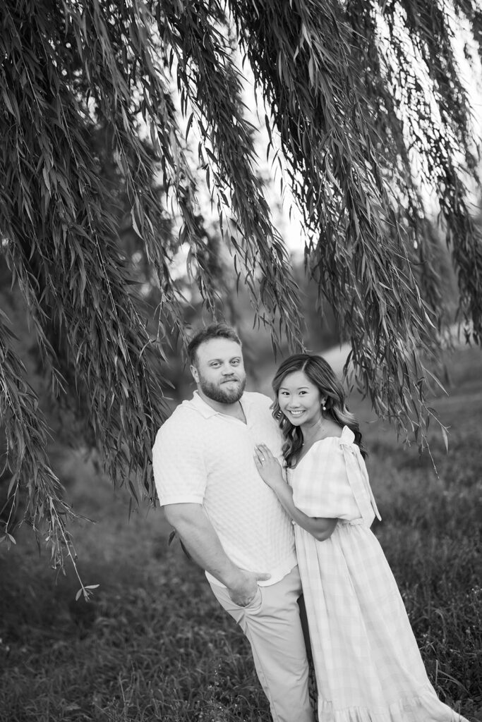 engagement session, a black & white photo of a couple posing under a willow tree