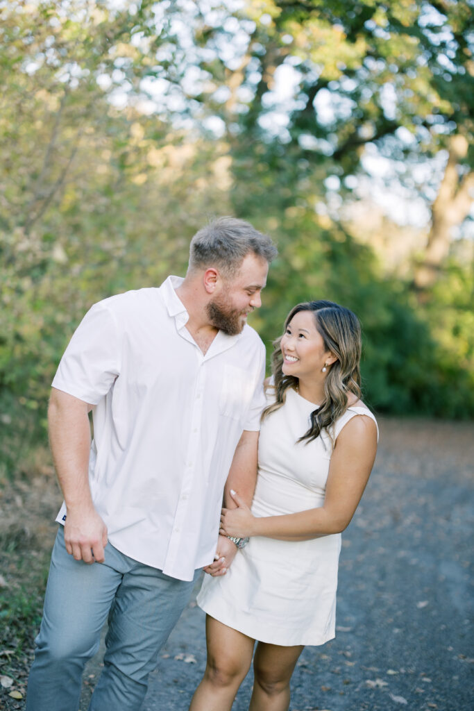 engagement session, a couple posing on a path surrounded by greenery