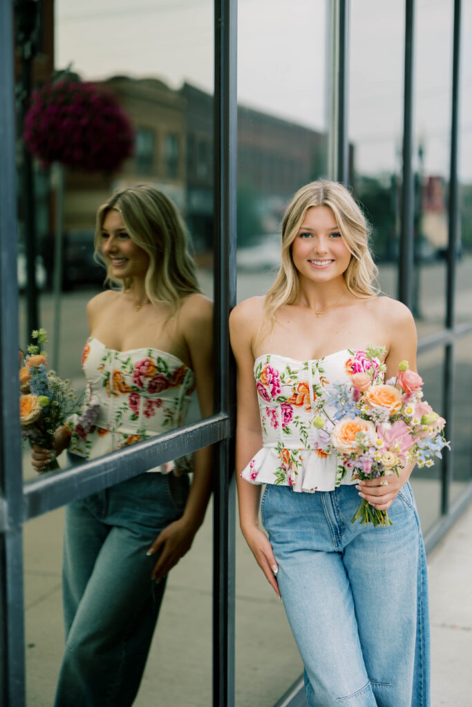 senior session, photo of a senior posing in the city with a bouquet