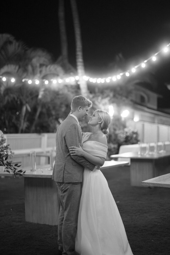 bride and groom dancing with bistro lights around them