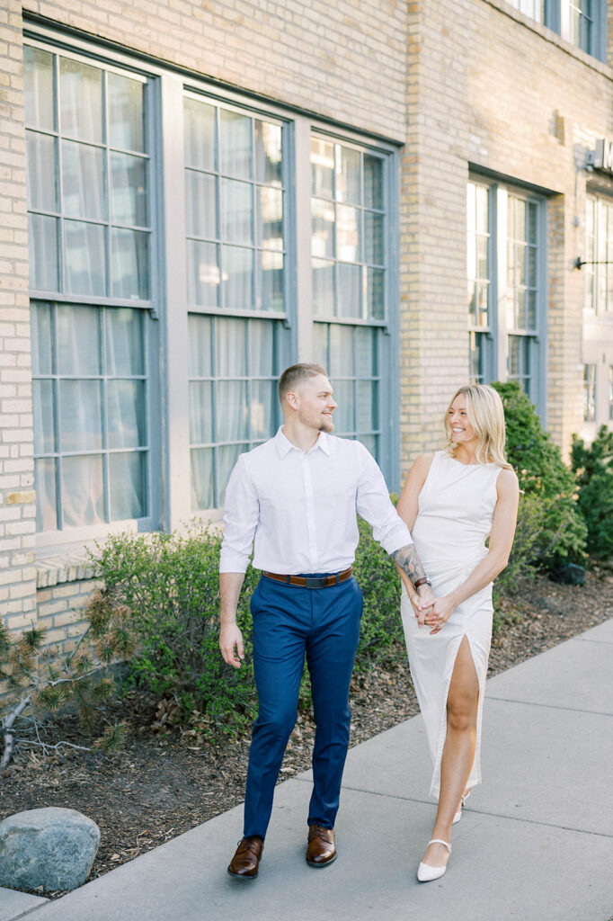 engagement session location idea, couple walking down the sidewalk downtown