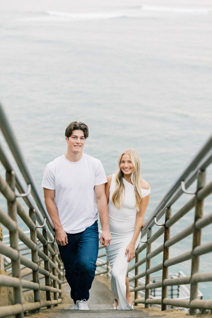 engagement session location idea, couple walking up stairs on a beach