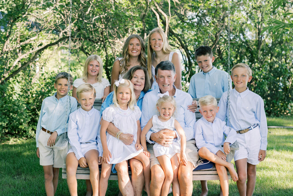 Family Portraits, multi-generational family posing in a green field with green trees in the background