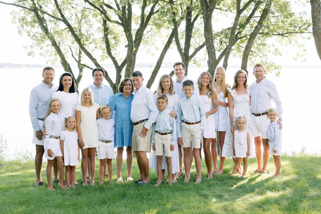 Family Portraits, multi-generational family posing in a green field with green trees in the background
