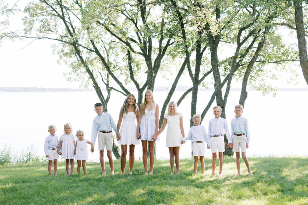Family Portraits, multi-generational family posing in a green field with green trees in the background