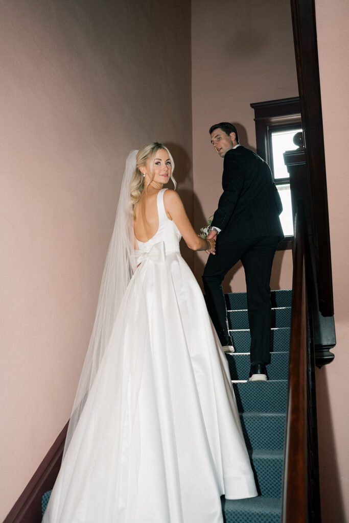bride and groom walking up the stairs