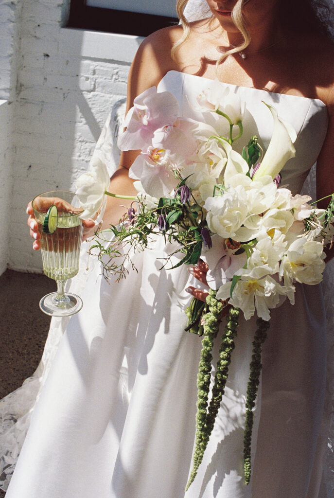 bride holding bouquet and drink